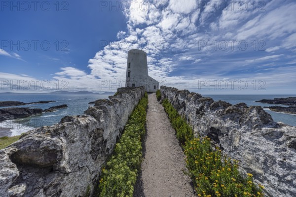 Twr Mawr Lighthouse, white lighthouse by the sea with blue sky and clouds, Ynys Llanddwyn,