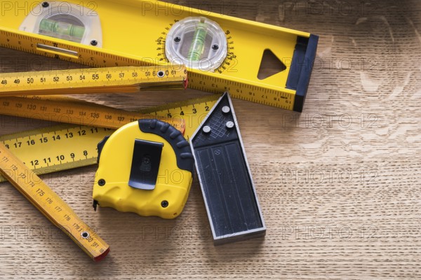 Oaken board with wooden meter measuring line construction level and square ruler maintenance