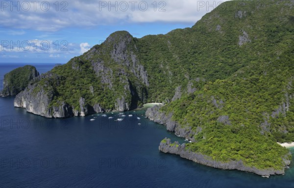 Aerial view of tropical Philippines island. White sand beach, rocks cliffs mountains with blue bay