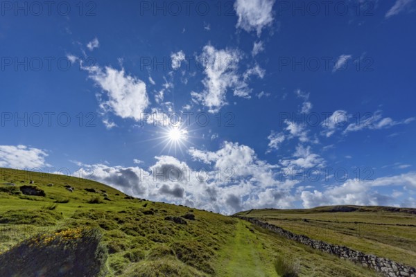 Hilly landscape with green meadows and stone wall, dry stone wall on the edge of Snowdonia National