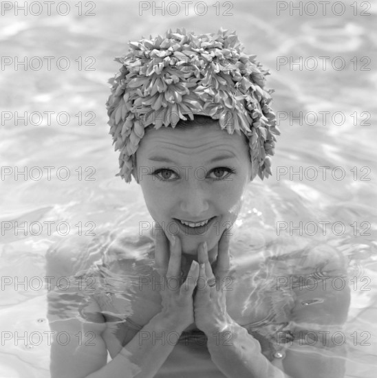 In the 1960s. A young woman pictured in the swimming pool wearing a typical 1960s bathing cap in a