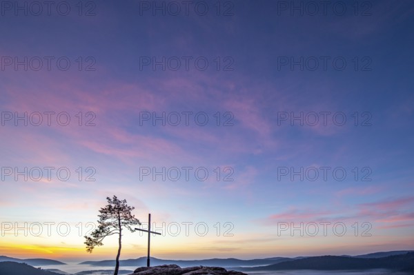 Summit cross on a sandstone rock in the middle of the forest. Landscape with a marvellous view over
