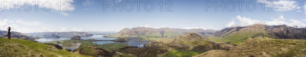 View over a wide mountain landscape with lakes and green terrain under a clear sky, Wanaka, New