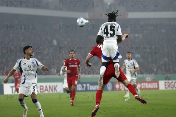 Fabio Baldé (HSV) leaps over a header by Michael Gregoritsch (SC Freiburg) during the match for the