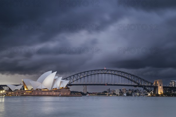 SYDNEY, AUSTRALIA, DECEMBER 03 2023: Sydney Opera House and Harbour Bridge at dusk during a summer