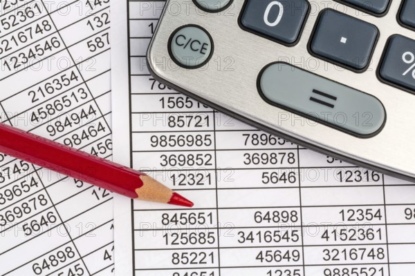 A calculator lies on the figures of a balance sheet and statistics. Symbol photo for turnover,
