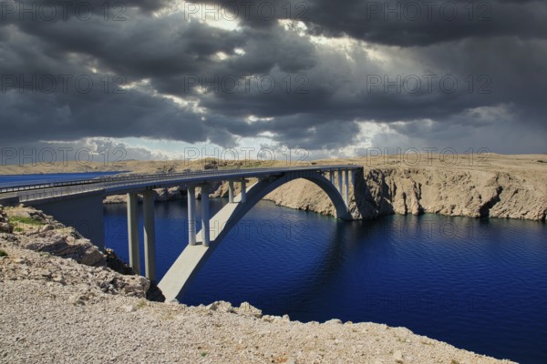 Impressive bridge spans a river under a dramatic, cloudy sky, Pag Bridge, Pag, Dalmatia, Croatia,