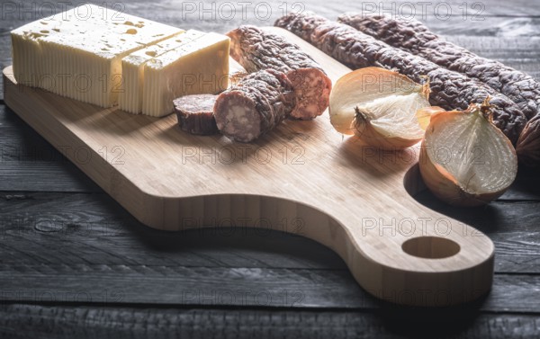Tasty meal with homemade smoked sausages from beef and pork, fresh cheese and onion, displayed on a
