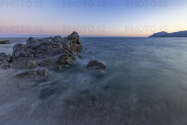 Rocks in the sea on the beach of Torre di Bari at sunset, long exposure, Torre di Bari, Bari Sardo,