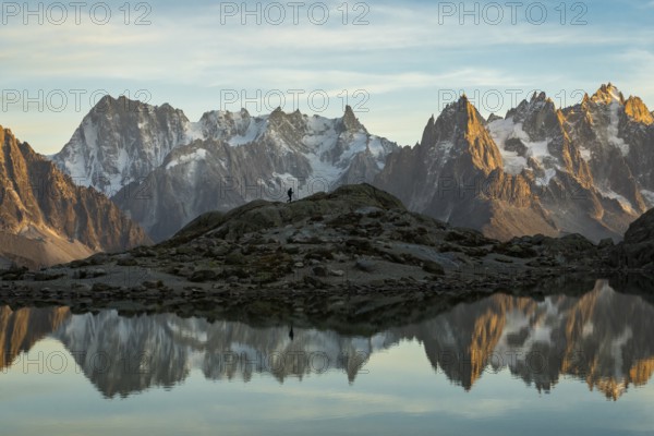 Silhouette of Hiker, Mountains and Reflection in Lac Blanc Lake at Sunset. Golden Hour. French