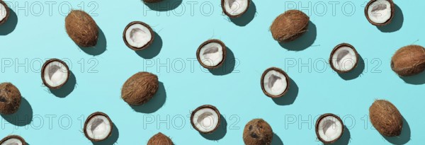 Creative layout of coconuts half on blue background. Tropical pattern, top view or flat lay. Hard