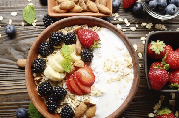 Flat lay top view at Fruit healthy muesli with banana strawberry almonds and blackberry with yogurt