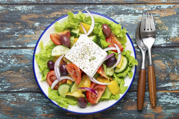 Traditional Greek Salad with Feta Cheese, Tomatoes, Bell Pepper, Cucumbers, Olives, Herbs in white