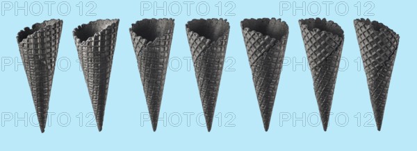 Various ice cream cones isolated on blue background. Various perspective of black waffle sugar