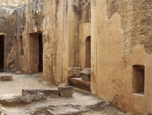 Tomb doors and niches in a carved sandstone wall forming a street like view in the temple of the