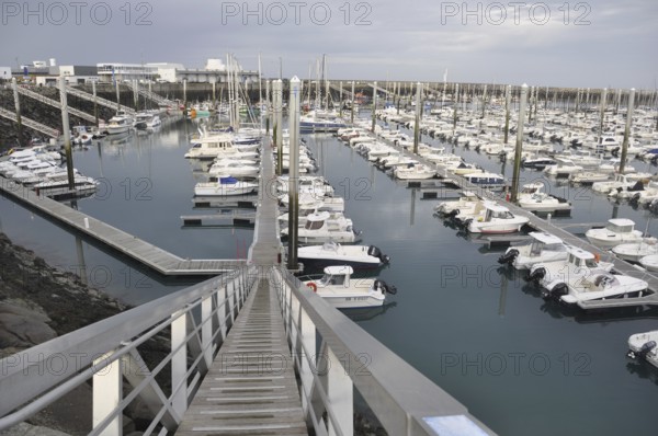 Saint-Quay Portrieux, A marina filled with white boats and docks under an overcast sky, viewed from