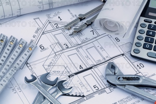 An architect's construction plan with a calculator. Symbolic photo for financing and planning a new