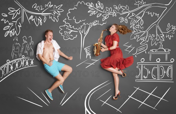 Love story concept of a romantic couple against chalk drawings background. Woman playing serenade