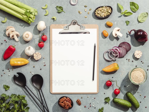 Food ingredients, salad serving utensils and clipboard with white paper sheet. Various of