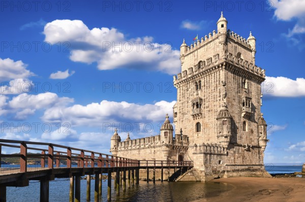 Belem tower and wooden bridge to it, Lisbon, Portugal at blue summer day sky with clouds. Medieval
