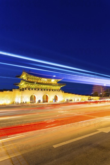 Colorful streaks of light from car lights on moving traffic in front of historic Gyeongbokgung
