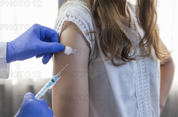 Close up doctor holding syringe and using cotton before make injection to patient in medical mask.