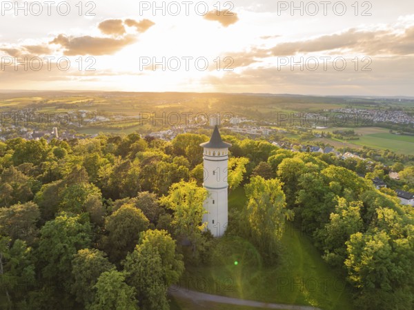 A tower rises in the sunset above the green forest and the vast countryside, Engelberg Tower,