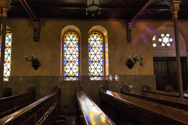 Incidence of light through stained glass windows, star, reflections, wooden benches, Great