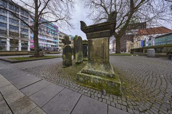 Historic gravestones, general architecture, pavement made of cobblestones and paving slabs, diffuse