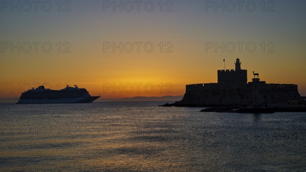 Cruise ship passing a fortress, calm, warm sky, sunrise, dawn, Fort of Saint Nikolaos, Mandraki