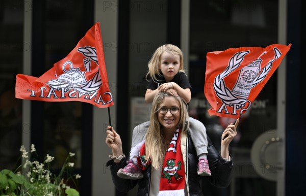 Woman, blonde, with girl, blonde, 4 years, sitting on shoulders, waving flags, flags of VfB
