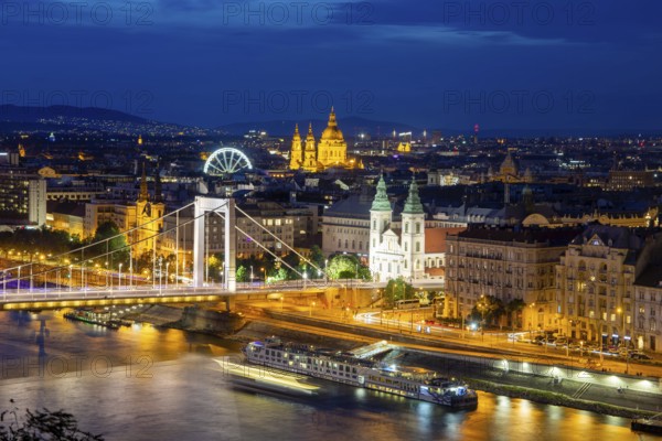 Evening panorama of Budapest with the Danube and the Elisabeth Bridge. The illuminated church in