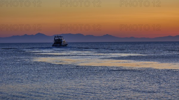 Lonely boat on the sea with mountains in the background, sunrise, dawn, Fort of Saint Nikolaos,