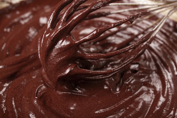 A bowl of chocolate dough, a whisk for whipping, baking, structure and consistency, homemade, top