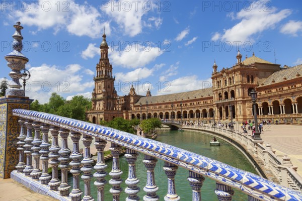Plaza de España in Seville with magnificent architecture and bridge on a sunny day with clouds,