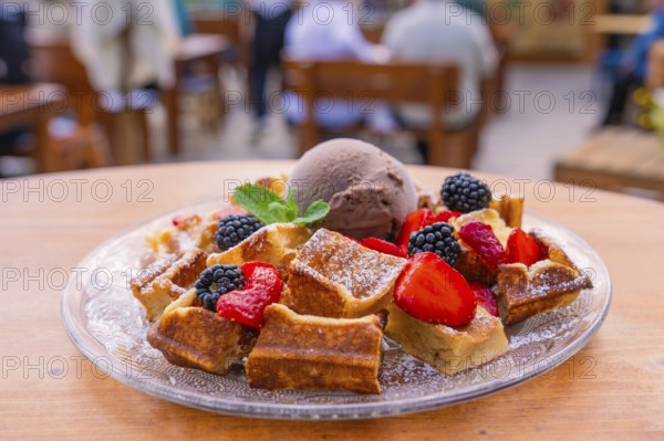 Appetising presentation of waffles with berries and ice cream on the terrace, Cafehäusle Calw,