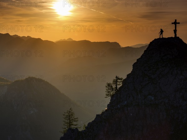 Mountaineers at the summit cross of the Kleiner Jenner at sunset, Reiteralpe in the background,