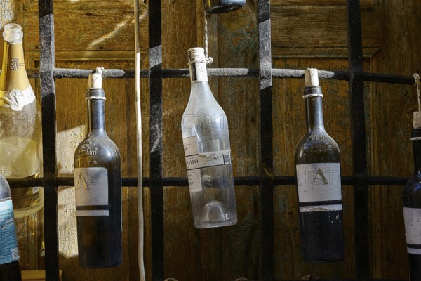 Various bottles hanging from a black metal grid, Symi Town, Symi, Dodecanese, Greek Islands,