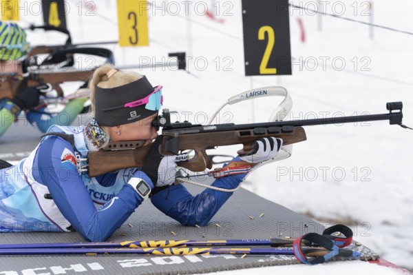 Kamchatka sportswoman biathlete Petrunova Kseniya rifle shooting in prone position. Biathlete in