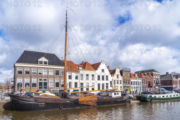 ZWOLLE, NETHERLANDS, MARCH 14, 2021: Old boats and barges in front of some nice gabled houses in