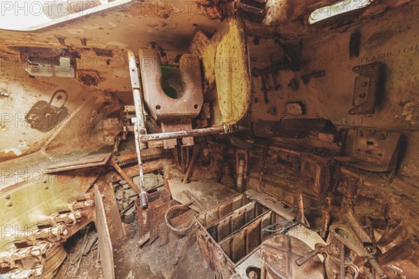 Dilapidated interior of a tank with rusty metal, full of old, rotting parts and structures, M41