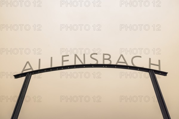Metal sign with the lettering Allensbach in front of a beige sky with Sahara dust, harbour,