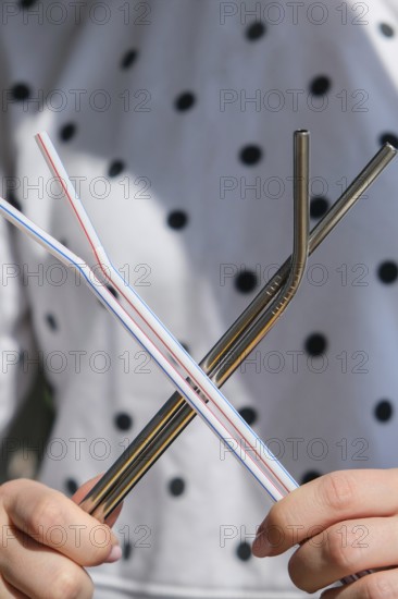 Woman holding Reusable Metal and plastic drinking Straws. Female Hand on reusable collapsible
