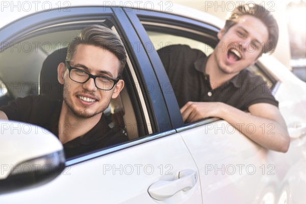 Enjoying travel. Beautiful young couple sitting on the front passenger seats and smiling while