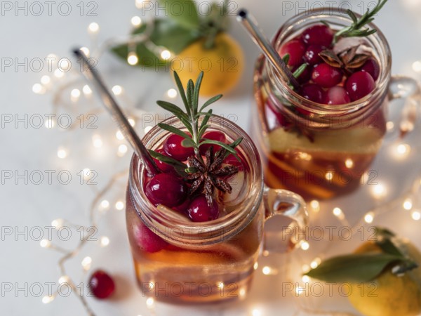 Winter sangria in mason jars with metal straws on christmas holiday background. Decorated fruit