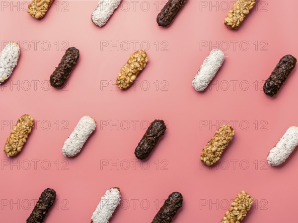 Pattern of different homemade eclairs on pink background. Top view of delicious healthy profitroles