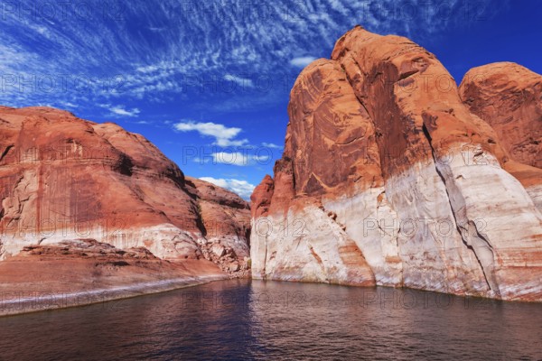Lake Powell is surrounded by magnificent red hills. Walk on the boat at sunset. Scenic huge