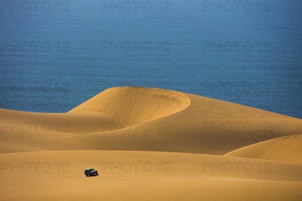 Dangerous and gorgeous jeep - safari through the huge sand dunes on the ocean shore. Atlantic coast