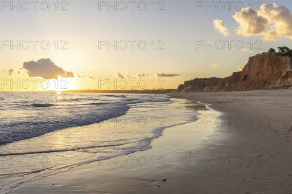 The golden sandy beach of Praia da Falésia, crystal clear sea water at low tide with the reflection