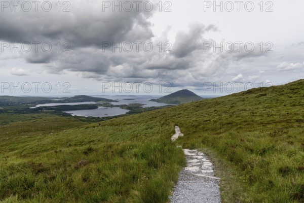 The hiking trail descending from Diamond Hill mountain peak in Connemara National Park with a view